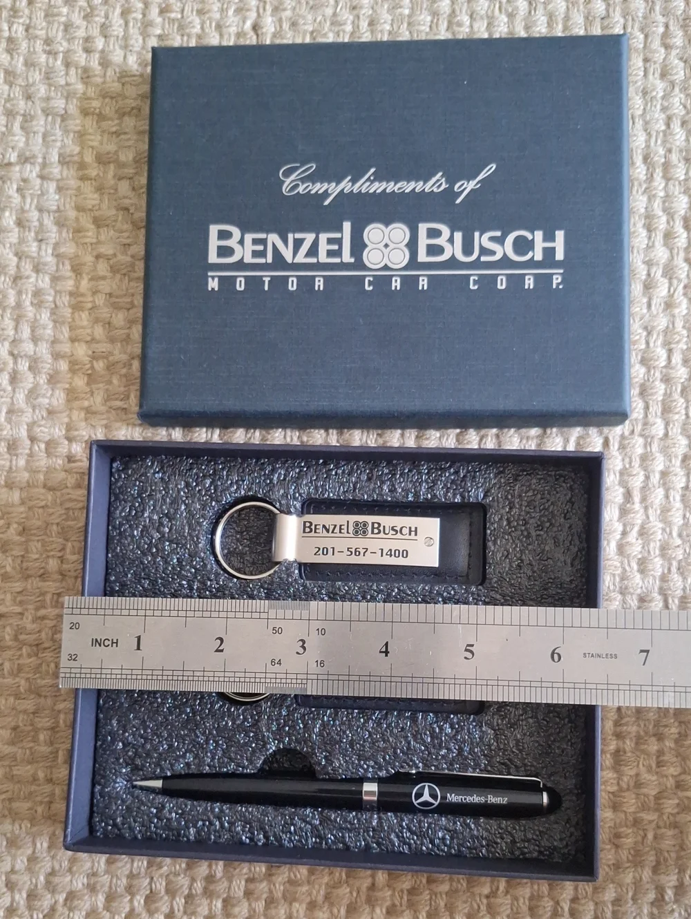 The seMercedes-Benz branded gift set featuring two keychains and a ballpoint pen